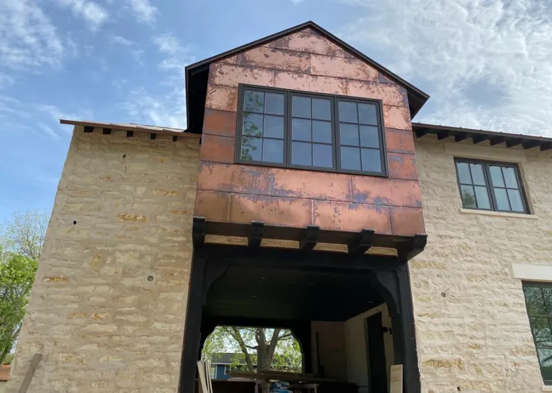 Copper metal panel facade on a stone building for Roof Repair in Evergreen